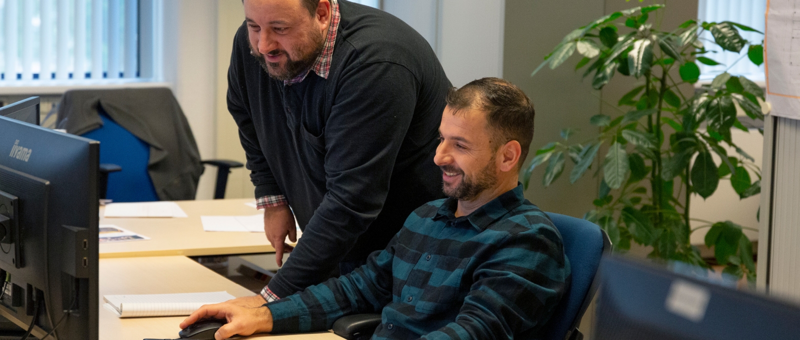 Overleg over project achter computer